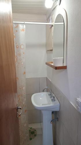 a white bathroom with a sink and a mirror at CABAÑAS BALCON DE PEHUMAYEN in Villa Carlos Paz