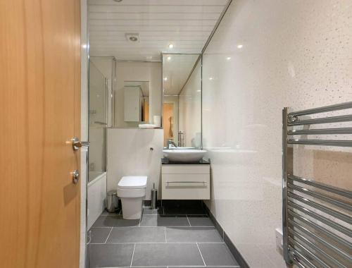 a bathroom with a sink and a toilet and a mirror at Glasgow 2bd near Hydro SECC City Centre Great Location in Glasgow