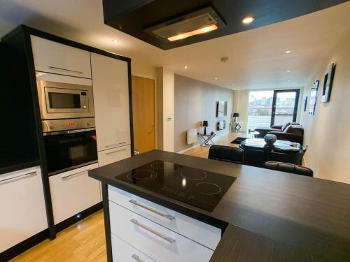 a kitchen with a counter top and a living room at Glasgow 2bd near Hydro SECC City Centre Great Location in Glasgow
