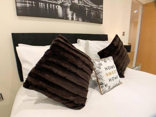 a bed with two black pillows and a book on it at Glasgow 2bd near Hydro SECC City Centre Great Location in Glasgow