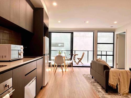a kitchen with a living room and a dining room at Brand new 1 bedroom apartment in Canberra Centre in Canberra
