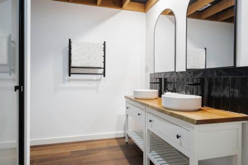 ein Badezimmer mit zwei Waschbecken und einem Spiegel in der Unterkunft The Cottage at Oak Tree Farm - Vineyards & Wildlife in Hastings