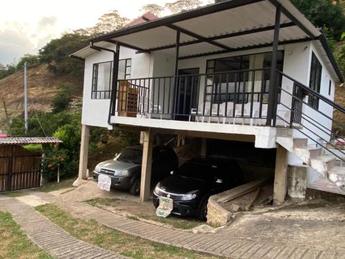 a house with two cars parked in the garage at CASALOMA in La Vega