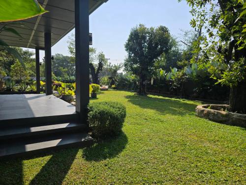 a view of a yard with a house at Live Specialty House in Ban Wang Pong