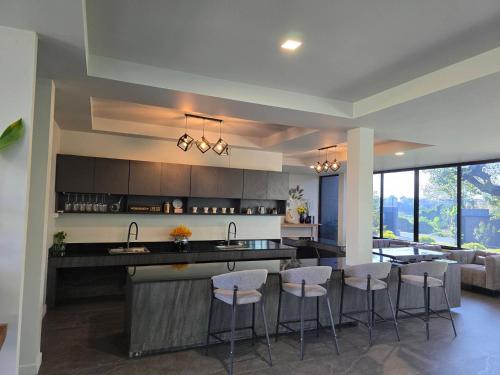 a kitchen and living room with a bar and bar stools at Live Specialty House in Ban Wang Pong