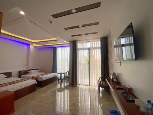 a hotel room with two beds and a dining room at Phi Anh Hotel in Bình Minh