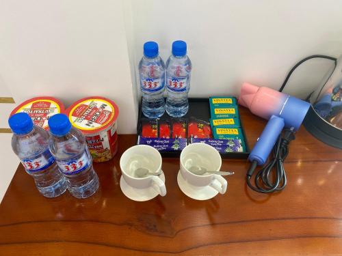 a wooden table with bottles of water and cups at Phi Anh Hotel in Bình Minh