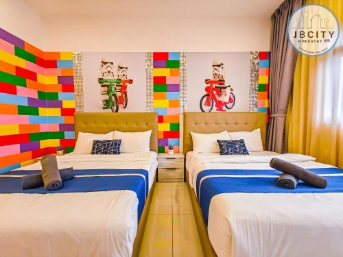 two beds in a room with colorful wall art at Pangsapuri Meridian by RR JBcity in Nusajaya