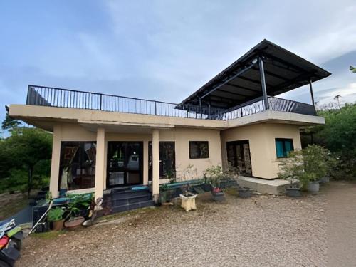 a house with a balcony on top of it at CitrusHill Family Glamping dan Villa Syariah Kebun Lemon in Ciater