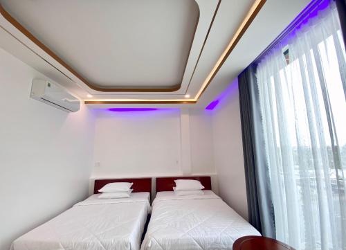 two beds in a room with a window at Phi Anh Hotel in Bình Minh