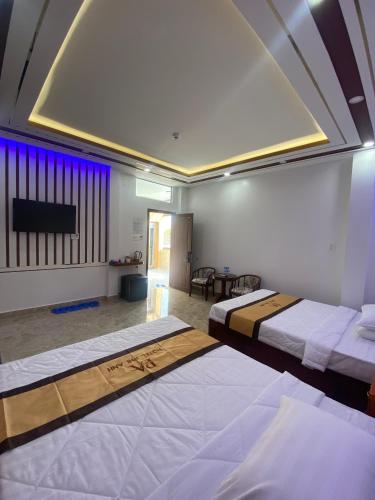 a hotel room with two beds and a tv at Phi Anh Hotel in Bình Minh