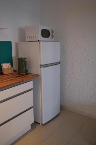 a white refrigerator with a microwave on top of it at Altes Höfchen in Duisburg
