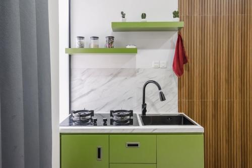 a kitchen with a stove and a sink at TwoSpaces Living at BSB Villa Maharaja, Malang in Tlekung