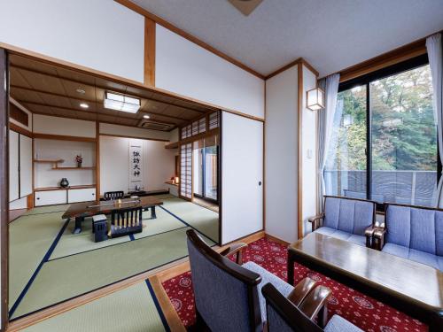 a living room with a table and chairs at Chousenkaku Kameya in Shimo-suwa