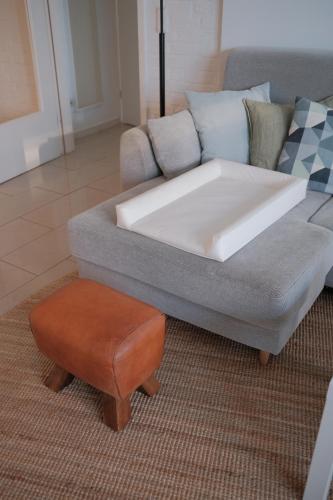 a living room with a couch and a stool at Altes Höfchen in Duisburg