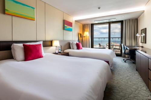 Ένα ή περισσότερα κρεβάτια σε δωμάτιο στο Ramada by Wyndham Jeju Hamdeok