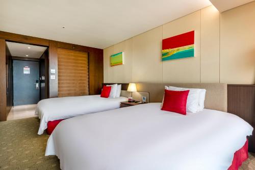Ένα ή περισσότερα κρεβάτια σε δωμάτιο στο Ramada by Wyndham Jeju Hamdeok