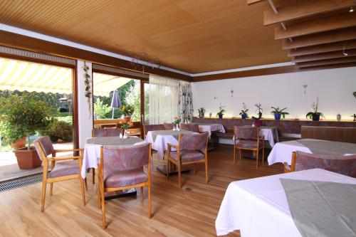 ein Restaurant mit Tischen und Stühlen in einem Zimmer in der Unterkunft Gästehaus Schmid-Lopez in Bad Wildbad