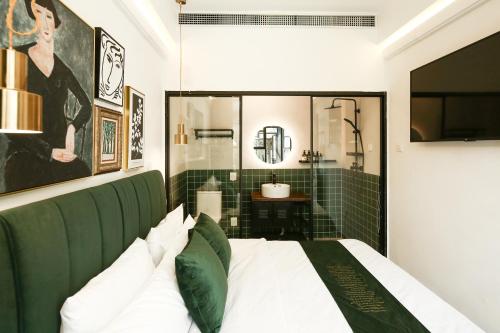 a bedroom with a green headboard and a bathroom at Goodnight hotel in the ancient Hutong in Beijing