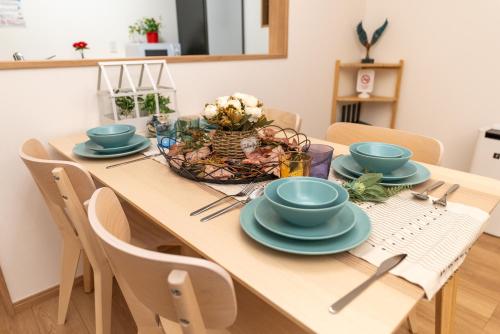a dining room table with blue dishes on it at Guest House Kubo Homes Tenjin Dori in Osaka