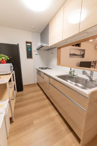 a kitchen with a sink and a refrigerator at Guest House Kubo Homes Tenjin Dori in Osaka
