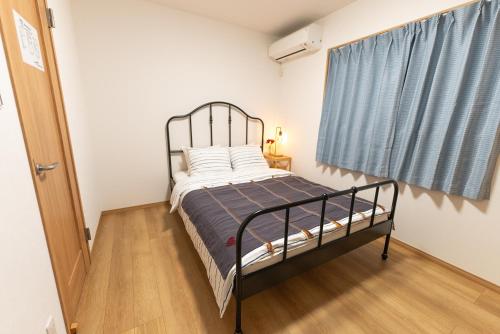 a bedroom with a bed with a metal frame at Guest House Kubo Homes Tenjin Dori in Osaka