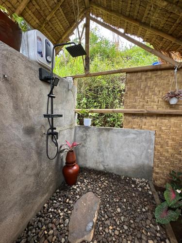 a shower in a building with a plant in a pot at Laa Cabana Lombok Glamping in Sapit