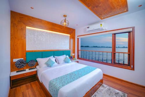 a bedroom with a large bed and a large window at Beach Paradise Day Cruise Houseboat in Alleppey
