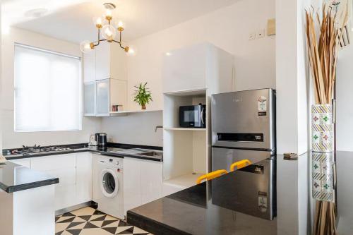 a kitchen with a stainless steel refrigerator and a dishwasher at Coastal Grandeur by Da Alohas, Candolim in Nerul