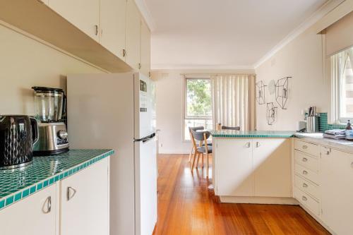 a kitchen with white cabinets and a green counter top at Charming Old Rye House Retreat in Rye