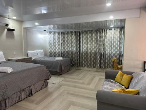 a hotel room with two beds and a couch at Moderno & acogedor Apartmento, 2 habitaciones , 4 camas in Concepción de Ataco