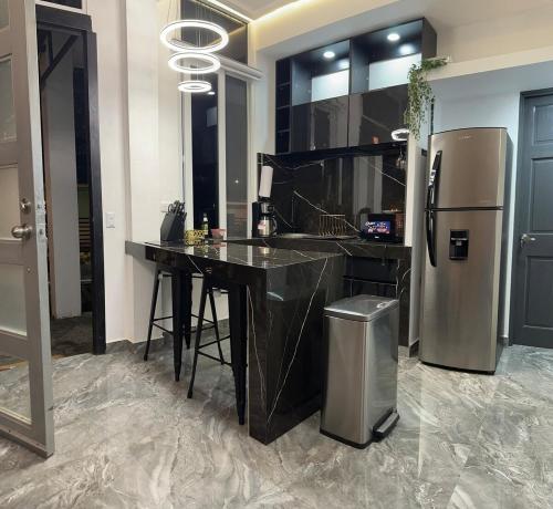 a kitchen with a black counter and a refrigerator at Moderno & acogedor Apartmento, 2 habitaciones , 4 camas in Concepción de Ataco