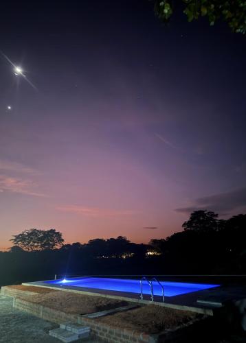 a swimming pool with blue lighting at night at Serene Sigiriya in Sigiriya