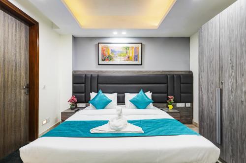 a bedroom with a large bed with blue pillows at 1BHK Suites Opp Marriott - Huda City Centre in Gurgaon