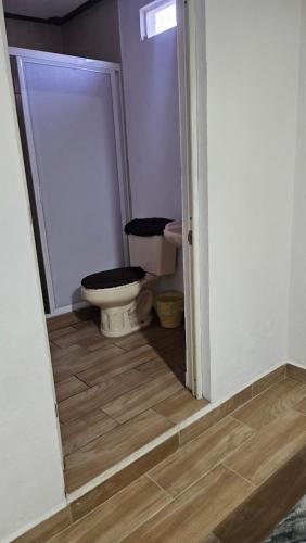 a bathroom with a toilet sitting next to a door at Posada villa aurora in Bernal