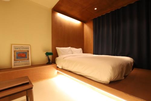 a bedroom with a bed with a light on it at lyrical Hotel Cheongju in Cheongju