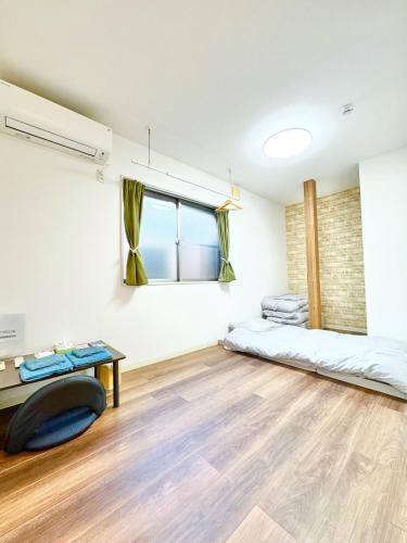 a room with a bed and a desk and a window at ansok青井 一軒家を改装した清潔なホステル 個室 in Tokyo