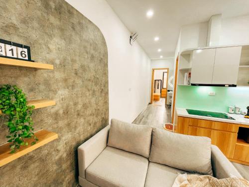 a living room with a couch and a kitchen at Mango Apartment and Homestay - HaNoi railway station in Hanoi