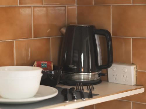 a coffee pot sitting on a shelf next to a plate at Manly Bunkhouse in Sydney
