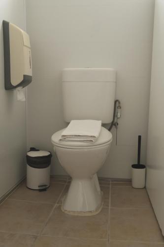 a white toilet in a bathroom with a paper dispenser at Manly Bunkhouse in Sydney
