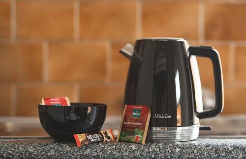a black coffee pot sitting on a counter next to a cup at Manly Bunkhouse in Sydney