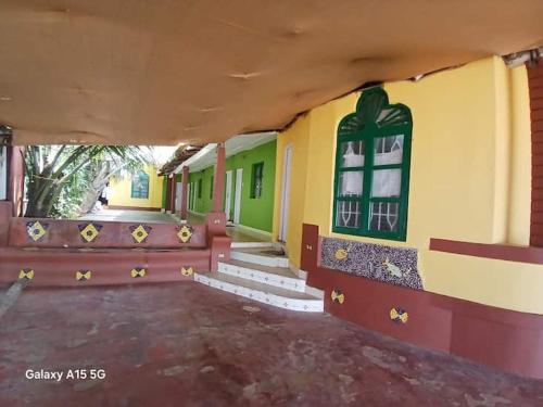 a building with a porch with a bench and windows at Furtado Beach Cottages in Benaulim