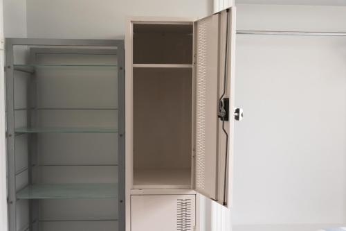 a cabinet with empty shelves in a kitchen at Manly Bunkhouse in Sydney