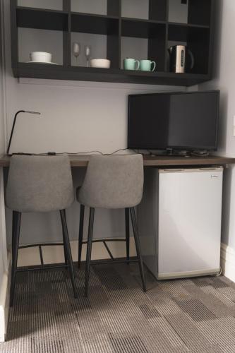 a desk with two chairs and a flat screen tv at Manly Bunkhouse in Sydney
