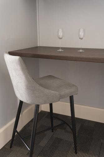 a chair sitting under a table with two wine glasses at Manly Bunkhouse in Sydney