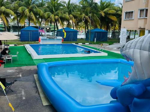 a large swimming pool with a blue pool slide at Capital O 91107 Pd Tiara By Delima Suites in Kampong Batu Empat Belas