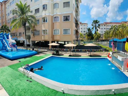 a pool at a resort with a water park at Capital O 91107 Pd Tiara By Delima Suites in Kampong Batu Empat Belas