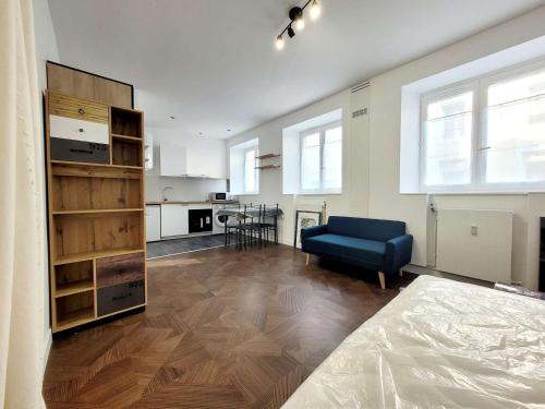 un salon avec un canapé bleu et une cuisine dans l'établissement Studio de charme avec Wifi en centre-ville - FR-1-675-45, à Boulogne-sur-Mer