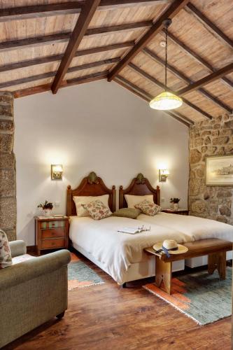 a bedroom with a large bed and a couch at Casa de Louredo in Paredes