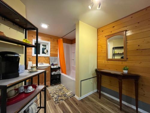 a bathroom with wooden walls and a sink and a mirror at Whispering Pines Farmhouse in Redmond
